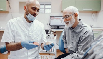 A dentist and patient discussing implant dentures 