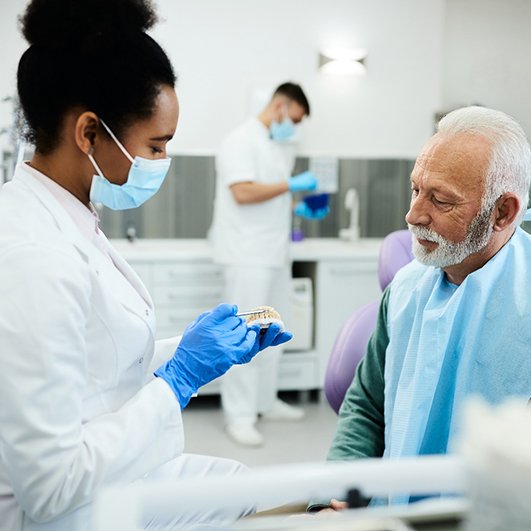 A dentist answering a patient’s denture questions