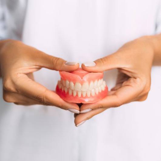 Lady presents viewer with dentures