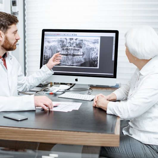 dentist showing a patient their X-rays before their dental implant procedure in Eatontown 