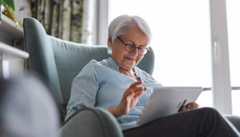 Woman looking at tablet while relaxing at home