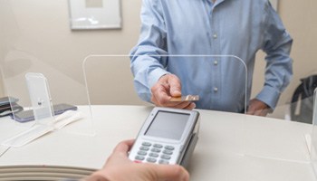 An adult man paying the cost of dentures 