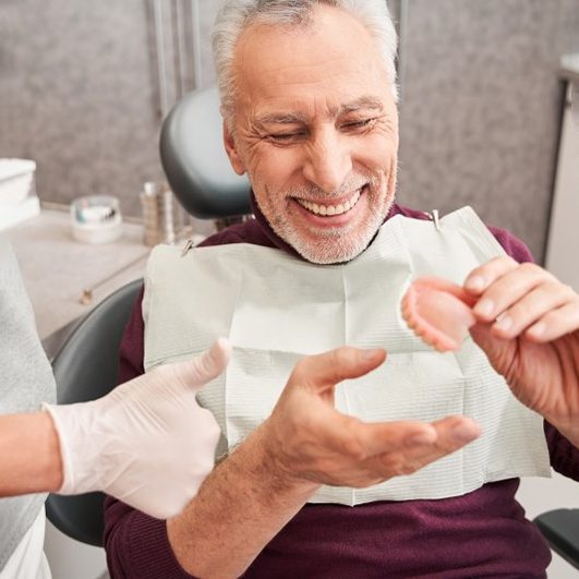 a patient smiling after receiving new dentures