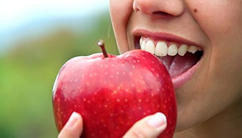 Woman about to bite into an apple