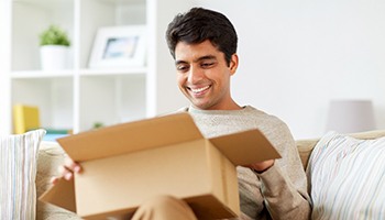 Man smiling while opening a package