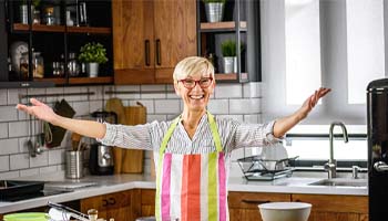 Woman preparing a meal after visiting implant dentist in Eatontown