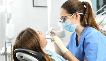 dental hygienist cleaning a patient’s teeth