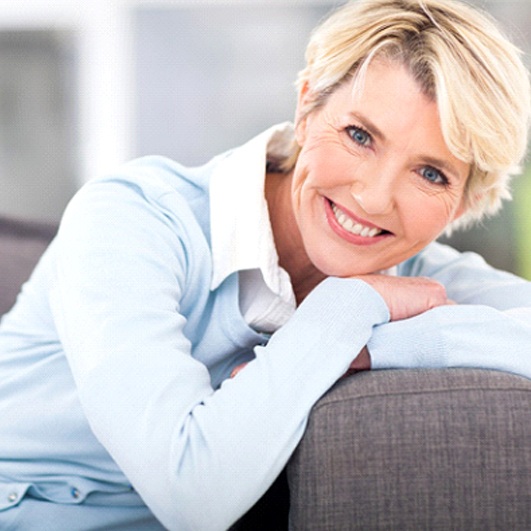 senior woman smiling while sitting on her couch
