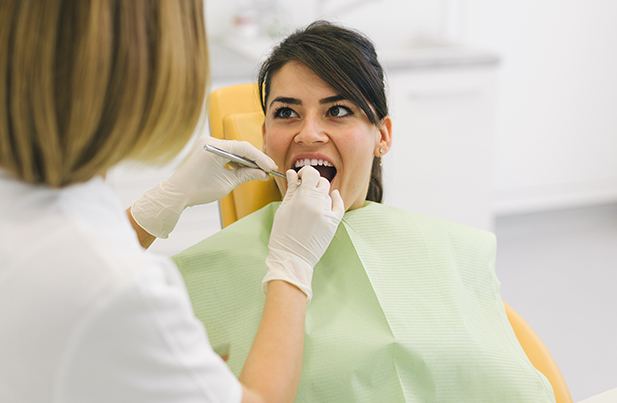 Woman in dental chair smiling at dentist