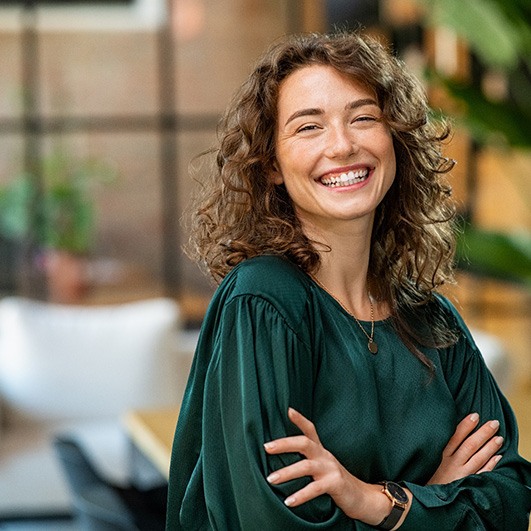 Woman smiling in lobby after smile makeover in Eatontown, NJ