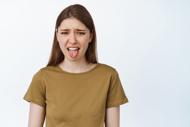 young woman sticking tongue out in disgust