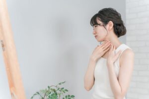 Woman looking at her neck in mirror 