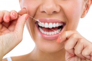 Woman flossing her teeth.